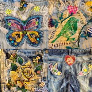 Pode incluir: Close-up de tecido de ganga com patches bordados. Apresenta uma borboleta, um pássaro verde, rosas amarelas e enfeites em forma de coração e pássaro. Os patches são costurados na ganga, criando um design de patchwork.