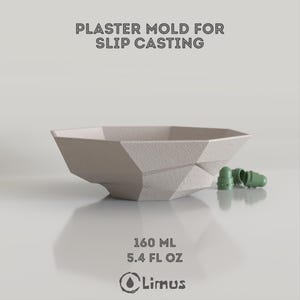 Può includere: Uno stampo in gesso geometrico beige chiaro per colaggio a colata, con il testo "PLASTER MOLD FOR SLIP CASTING". La ciotola ha una capacità di 160 ml ed è accompagnata da tre piccoli oggetti verdi. È visibile anche il logo del marchio "Limus".