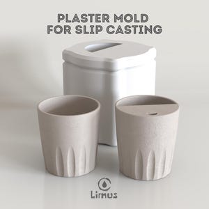以下が含まれることがあります： 「PLASTER MOLD FOR SLIP CASTING」のテキストが入った、白い石膏スリップキャスティング用型。 縦溝のあるベージュ色のセラミックカップが2つ、型の前にあります。 下部にはLimusのロゴがあります。
