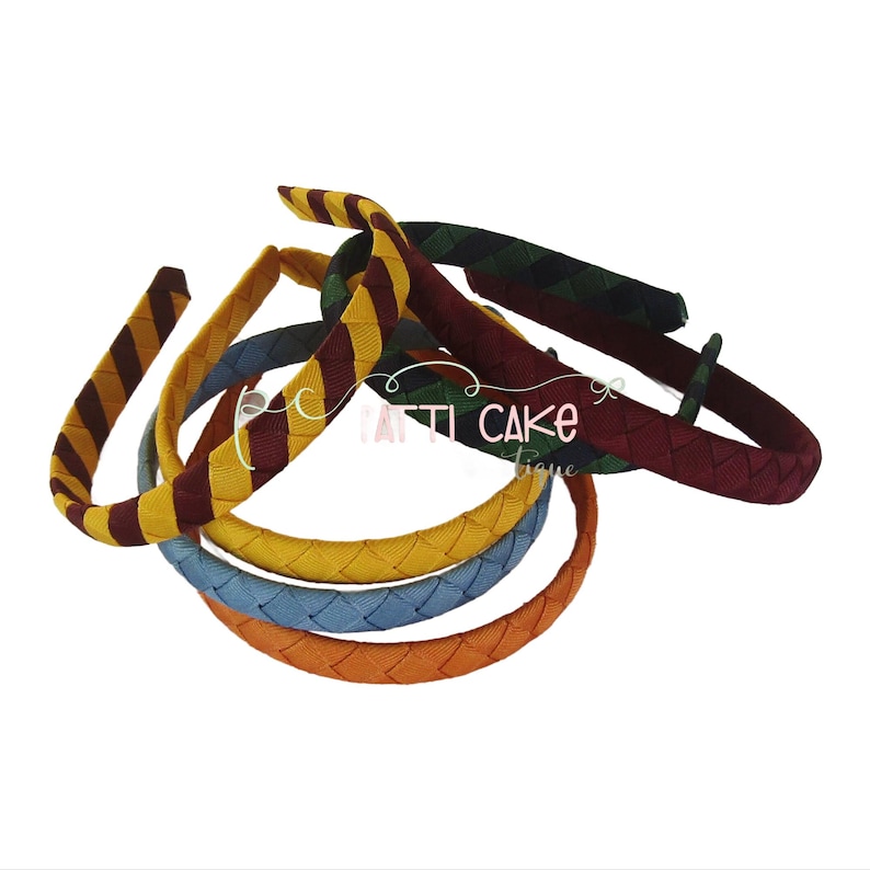 May include: A collection of braided headbands in various colors, including yellow, blue, orange, green, and burgundy. Some headbands feature striped patterns. The image includes the text "PATTI CAKE Tique".