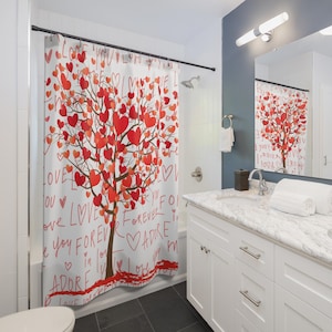 May include: White shower curtain with a tree design, featuring red heart-shaped leaves. The words "LOVE", "FOREVER", and "ADORE" are written in red script. The curtain is in a bathroom with a white vanity and a mirror.