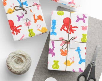May include: Gift-wrapped presents with colorful balloon animal patterns, tied with twine and heart-shaped tags. A spool of twine, scissors, and blank tags are also visible, suggesting a festive theme.