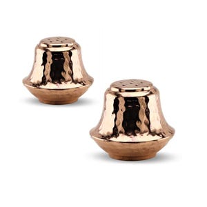 May include: Two copper-colored salt and pepper shakers. Each shaker has a textured, hammered finish and a flared base. The top of each shaker has several small holes for dispensing the contents. The shakers are designed with a classic, elegant shape.