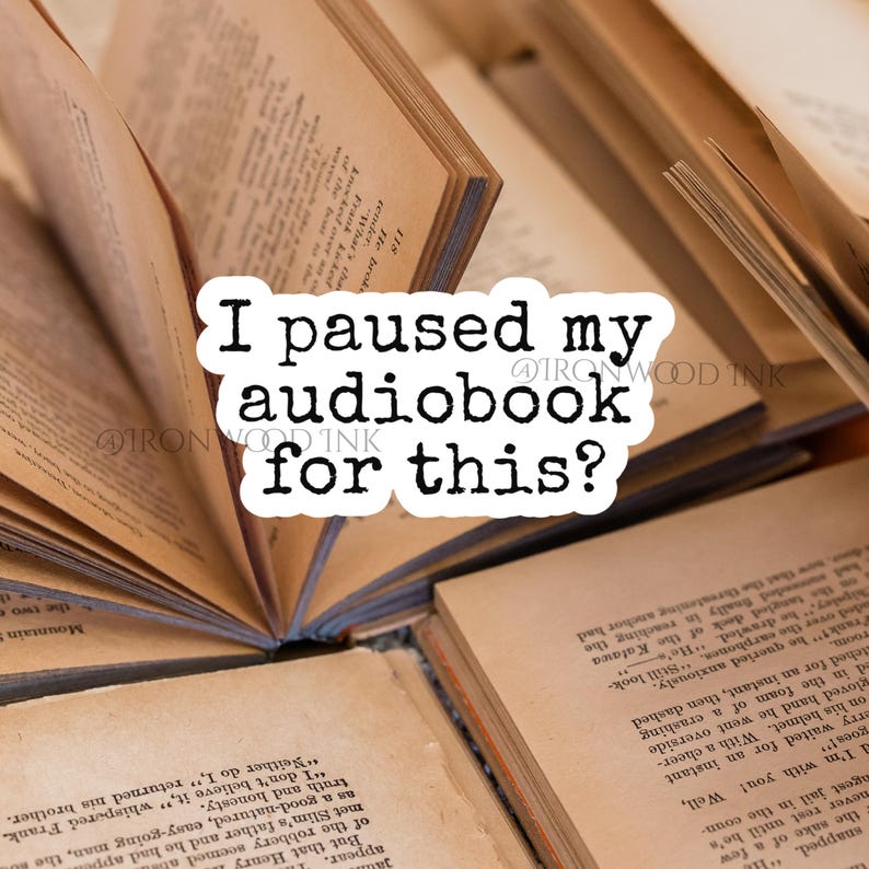 Pu&ograve; includere: Un adesivo bianco con testo nero in stile macchina da scrivere che recita I paused my audiobook for this? L'adesivo &egrave; posizionato sopra diversi libri aperti con pagine invecchiate color crema e testo stampato in un carattere serif.