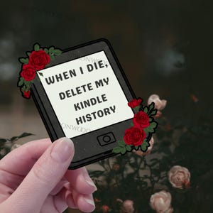 May include: A rectangular sticker shaped like an e-reader with a black frame and a white screen displaying the black text WHEN I DIE, DELETE MY KINDLE HISTORY. The device is decorated with clusters of red roses and green leaves on the corners.