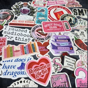 Pu&ograve; includere: Una collezione di adesivi in vinile assortiti con illustrazioni a tema librario, tra cui pile di libri colorati, cuori e design basati su testo come Romance Girlie, Spicy Book Club e varie frasi umoristiche sulla lettura e gli audiolibri.