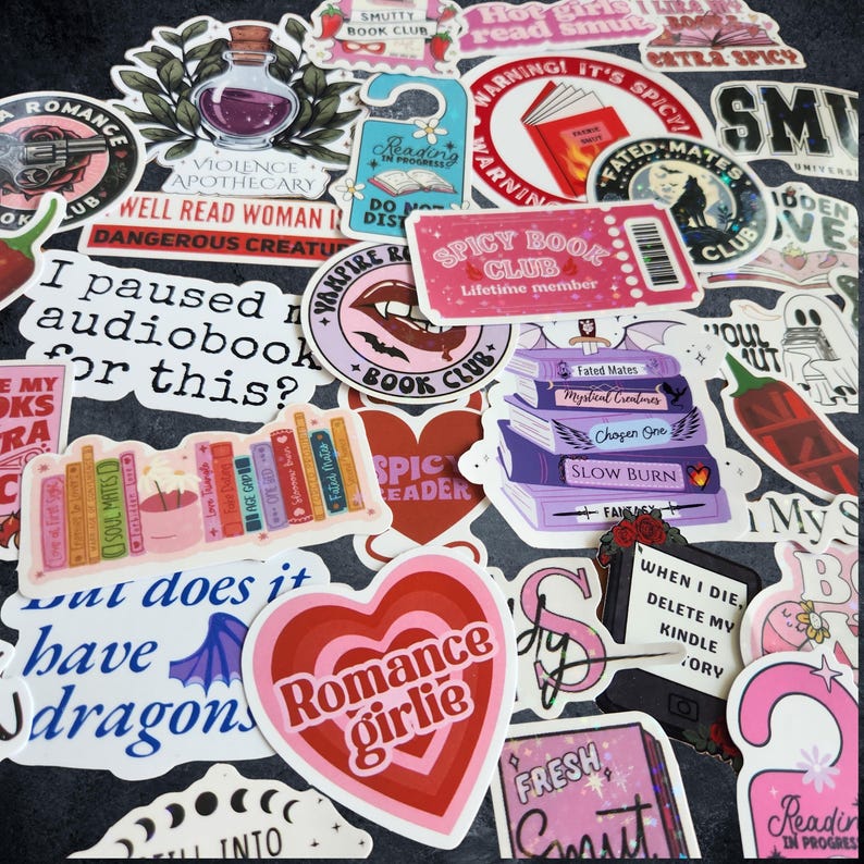 Pu&ograve; includere: Una collezione di adesivi in vinile assortiti con illustrazioni a tema librario, tra cui pile di libri colorati, cuori e design basati su testo come Romance Girlie, Spicy Book Club e varie frasi umoristiche sulla lettura e gli audiolibri.
