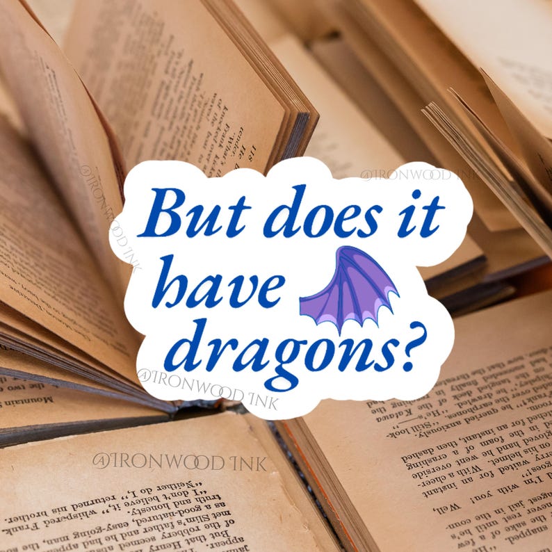 May include: A white die-cut sticker featuring the blue text "But does it have dragons?" and a small purple dragon wing illustration. The sticker has a scalloped edge and is positioned against a background of open, aged book pages with visible text.