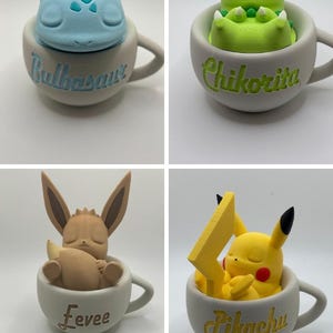 May include: Four ceramic mugs, each featuring a different Pok&eacute;mon character. The mugs are light gray with the character's name written on the side. The characters include Bulbasaur, Chikorita, Eevee, and Pikachu, each in a sleeping pose.
