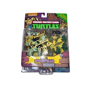 Peut inclure: Une figurine Donatello des Tortues Ninja dans son emballage d'origine. L'emballage présente le logo Nickelodeon, les mots "Teenage Mutant Ninja Turtles" et le nom "Donatello". La figurine est signée.