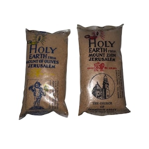 May include: Two sealed bags of Holy Earth from Jerusalem. One bag is labeled "Mount of Olives" and the other "Mount Zion." Each bag features text and illustrations, including a church and a cherub.