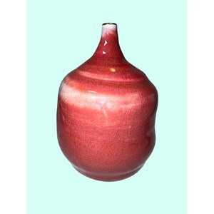 Könnte beinhalten: Eine bauchige Keramikvase mit einer glänzenden roten Glasur, die ein feines Rissmuster aufweist. Die Vase hat einen schmalen Hals, der in einen breiteren, abgerundeten Körper übergeht, mit einem dezenten weißen Verlauf am oberen Rand und einem Goldrand.