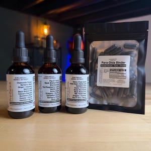 May include: Three amber glass bottles with black droppers and labels, alongside a black pouch of capsules. The bottles are labeled "Pre-Para-X", "Para-Dida", and "Para-Nada", with ingredient lists. The pouch is labeled "Para-Dida Binder".