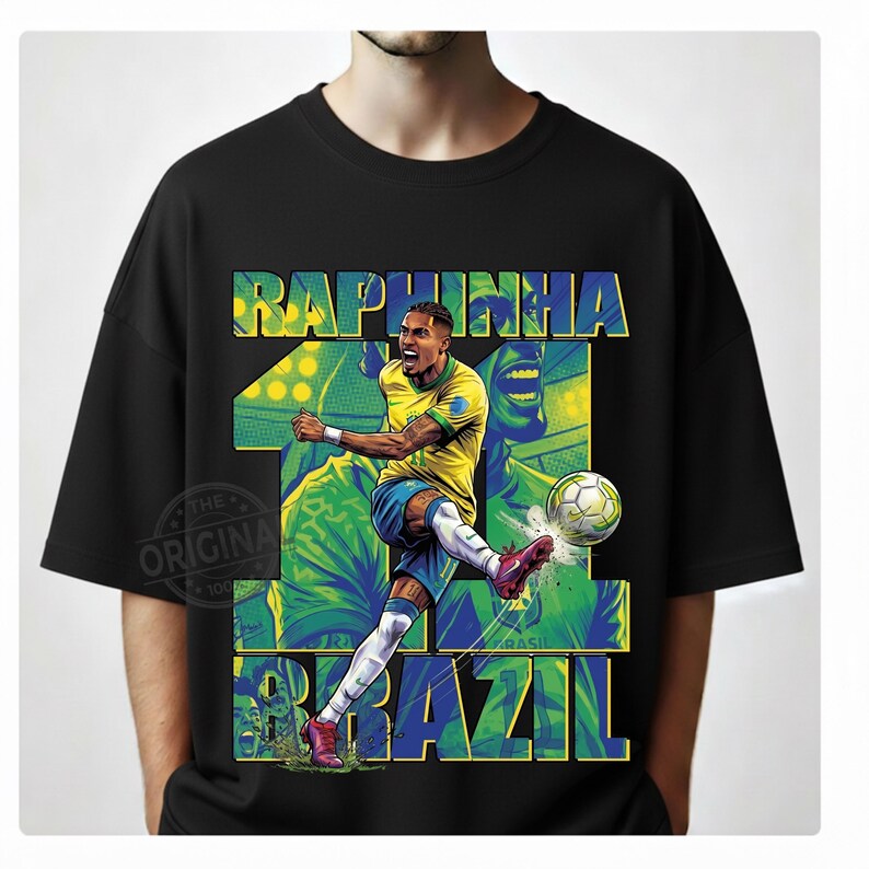 May include: Black t-shirt featuring a graphic of a soccer player kicking a ball. The design includes the name "Raphinha" and the word "Brazil" in blue and green. The player is wearing a yellow and blue uniform.