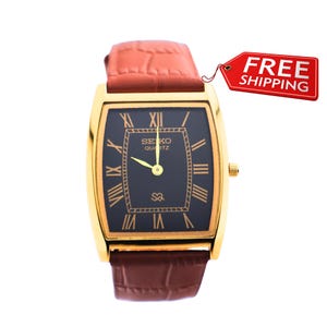 Style vestimentaire Seiko Slim vintage Barrel Tank Montre à quartz pour homme avec cadran noir et nouveau bracelet en cuir camel
