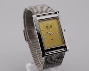 Reloj de pulsera vintage Seiko Slim Quartz para hombre, esfera amarilla y caja plateada, transmitido de generación en generación.