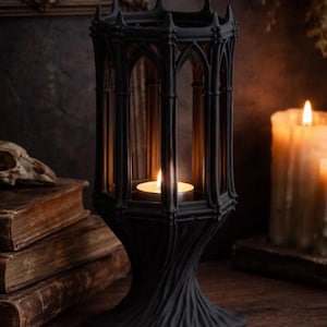 May include: A black gothic candle lantern with a lit candle inside. The lantern has an arched design and sits on a wooden surface. The text "DIGITAL STL FILE" is at the top of the image. The background includes old books and a lit candle.