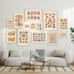 K&ouml;nnte beinhalten: Eine Sammlung von Vintage-Rahmenbildern mit Wappen. Die Drucke sind an einer wei&szlig;en Wand &uuml;ber einem grauen Sofa mit wei&szlig;en Kissen angebracht. Die Drucke sind in verschiedenen Gr&ouml;&szlig;en und mit unterschiedlichen Designs.