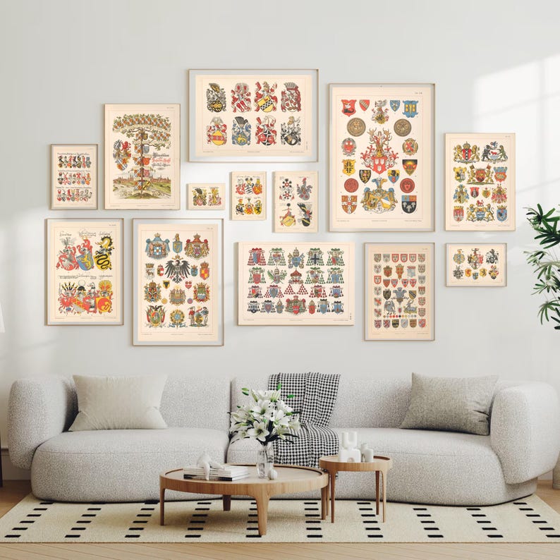 K&ouml;nnte beinhalten: Eine Sammlung von Vintage-Rahmenbildern mit Wappen. Die Drucke sind an einer wei&szlig;en Wand &uuml;ber einem grauen Sofa mit wei&szlig;en Kissen angebracht. Die Drucke sind in verschiedenen Gr&ouml;&szlig;en und mit unterschiedlichen Designs.