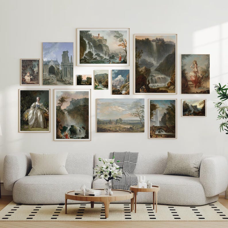 May include: A gallery wall featuring a collection of framed landscape paintings. The paintings depict various scenes of nature, including waterfalls, forests, and mountains. The paintings are arranged in a grid pattern on a white wall.