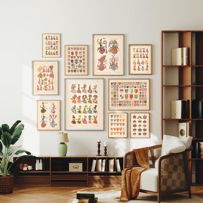 K&ouml;nnte beinhalten: Eine Sammlung von Vintage-Drucken mit bunten heraldischen Schilden und Wappen. Die Drucke sind gerahmt und an einer wei&szlig;en Wand mit einem Holzregal und einem wei&szlig;en Sessel ausgestellt.