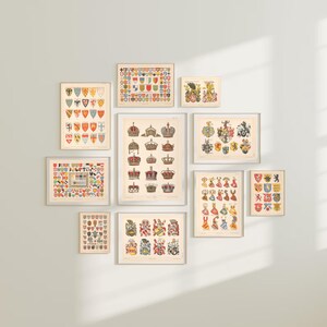 K&ouml;nnte beinhalten: Eine Sammlung von neun Vintage-Drucken mit bunten Wappen und Wappenschildern. Die Drucke sind in Wei&szlig; gerahmt und in einem Rastermuster an einer wei&szlig;en Wand angeordnet.