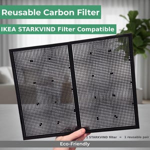 Op de afbeelding: Een zwart, rechthoekig, herbruikbaar koolstoffilter, compatibel met IKEA STARKVIND luchtreinigers. Het filter heeft een rasterpatroon en is gelabeld met "Reusable Carbon Filter" en "Eco-Friendly". De tekst luidt ook "1 STARKVIND filter = 1 reusable pair".