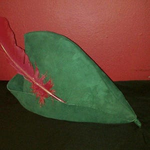 May include: A green felt hat with a red feather attached to the side.