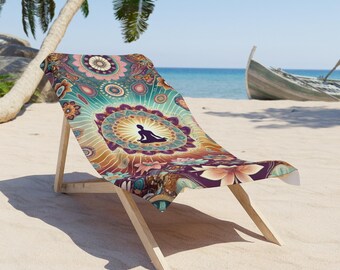 May include: A beach chair featuring a vibrant, multi-colored fabric cover with a central mandala pattern and a silhouette of a person in a seated meditation pose. The chair has a light-colored wooden frame and is positioned on a sandy beach.