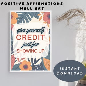 May include: A framed wall art print with the text "give yourself CREDIT just for SHOWING UP" in a white, floral-themed design. The words "POSITIVE AFFIRMATIONS WALL ART" are at the top. A dark blue circle with the words "INSTANT DOWNLOAD" is at the bottom.