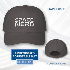 May include: Dark grey embroidered adjustable hat with the text "SPACE NERD" in white. The hat has an adjustable band and is available in 10 colours. The image shows the front and back of the hat.