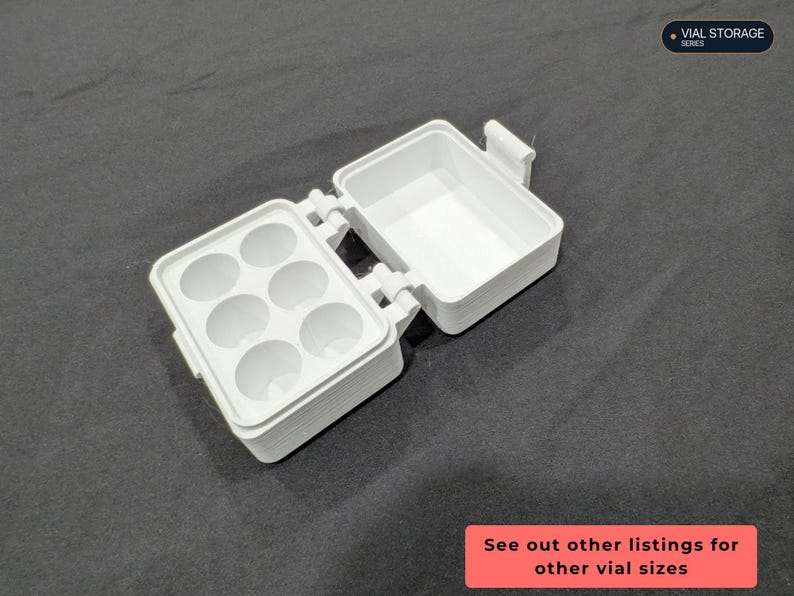 Op de afbeelding: Een witte plastic opbergdoos met een scharnierend deksel, voorzien van zes ronde uitsparingen aan de ene kant en een open vak aan de andere kant. De tekst VIAL STORAGE SERIES en See out other listings for other vial sizes is zichtbaar.