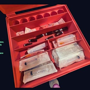 B12 injection supply organizer on deep indigo fabric backdrop