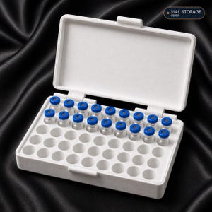 May include: A white plastic storage box with a hinged lid, featuring a grid of circular slots. The box contains sixteen small clear glass vials with blue caps. The text VIAL STORAGE SERIES is printed in the upper right corner of the image.