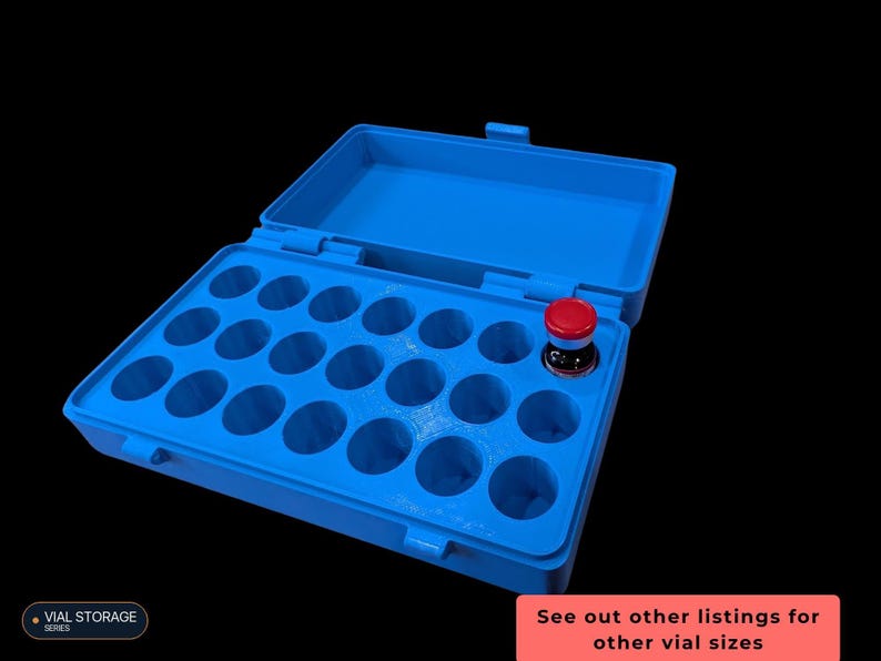 Op de afbeelding: Een felblauwe rechthoekige opbergdoos met een scharnierend deksel, voorzien van eenentwintig ronde uitsparingen voor het organiseren van flesjes. E&eacute;n klein glazen flesje met een rode dop is in een opening geplaatst. Tekst luidt VIAL STORAGE SERIES.