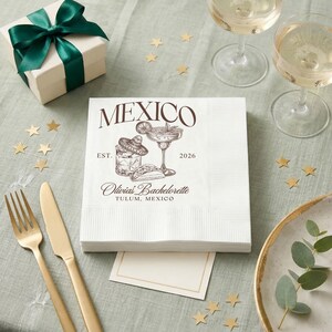 Puede incluir: Una taza de cerámica blanca con un asa negra y el texto "But First, Coffee" en negro, con una fuente de estilo manuscrito. La taza está sobre una superficie blanca.