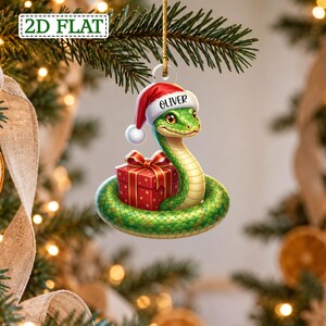 Enfeite personalizado de uma adorável serpente verde com gorro de Papai Noel e presente, bola de Natal em forma de cobra enrolada, presente de Natal exclusivo para fãs de répteis.