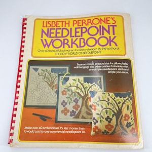 May include: A vintage needlepoint workbook by Lisbeth Perrone. The cover features a yellow and orange design with the title "Needlepoint Workbook." The book showcases canvas embroidery designs, including tree and floral patterns. The book is spiral-bound with a red spine.