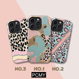 Peut inclure: Trois coques de t&eacute;l&eacute;phone avec des motifs uniques. Les coques pr&eacute;sentent des imprim&eacute;s l&eacute;opard, des formes abstraites et des accents de paillettes roses, bleus et dor&eacute;s. Les coques sont num&eacute;rot&eacute;es "NO.3", "NO.1" et "NO.2", avec la marque "PCMY".