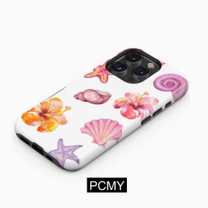 Puede incluir: Una funda blanca para iPhone con un diseño de acuarela de conchas marinas, estrellas de mar y flores de hibisco. La funda tiene un recorte para el objetivo de la cámara.