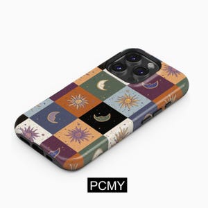 Puede incluir: Una funda para teléfono con un diseño de patchwork colorido con soles y lunas. La funda es negra y tiene un recorte para la cámara.