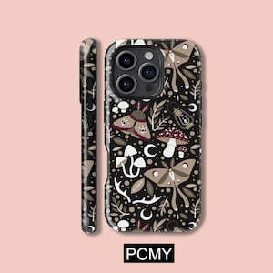 Puede incluir: Funda de teléfono negra con un diseño caprichoso con polillas, setas, hojas y lunas crecientes. La funda tiene un acabado mate y un parachoques protector. El diseño incluye elementos marrones, blancos y beige sobre un fondo negro.