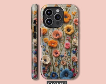 Puede incluir: Funda de teléfono con bordado floral en tonos naranja, amarillo, rosa y azul. El fondo es de color beige claro y el texto "PCMY" es visible en la parte inferior. Diseño con flores.