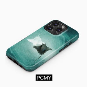 May include: A teal phone case with a watercolour design of two manta rays in the ocean. One ray is white, and the other is black. The case has a black border and the text "PCMY" in a black rectangle.