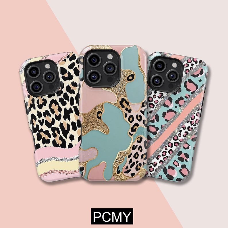 Peut inclure: Trois coques de t&eacute;l&eacute;phone aux motifs uniques. L'une pr&eacute;sente un imprim&eacute; l&eacute;opard avec des rayures roses et jaunes, une autre un motif abstrait rose, bleu et dor&eacute;, et la troisi&egrave;me un imprim&eacute; l&eacute;opard avec des rayures roses et argent&eacute;es. Le texte "PCMY" est en bas.