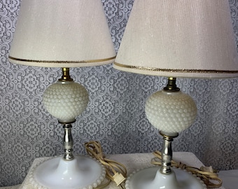 May include: Pair of white milk glass table lamps with beaded bases and white lampshades with gold trim.