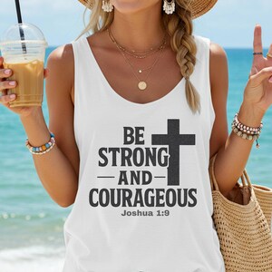 Könnte beinhalten: Weißes Tanktop mit dem Text "BE STRONG AND COURAGEOUS" und einem Kreuz. Der Text ist fett gedruckt. Die Person trägt einen Strohhut und Schmuck am Strand.