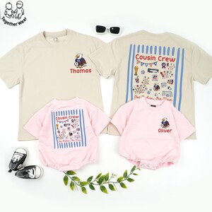 May include: A family matching set of t-shirts and rompers in beige and pink. The beige shirts have an eagle graphic and the name "Thomas". The pink rompers and a beige shirt have "Cousin Crew" text and graphics. The romper has the name "Oliver".