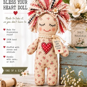 May include: A fabric doll with a beige floral body, a red polka-dot heart patch, and a fringe of red, white, and black fabric strips for hair. A tag attached to the neck reads, "TAKE A DEEP BREATH, SUGAR." The doll features embroidered eyes and a smile.