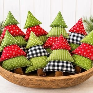 Op de afbeelding: Een verzameling gevulde stoffen kerstboomornamenten in een houten kom. Elke boom bestaat uit gestapelde driehoekige segmenten met diverse patronen, waaronder groene stippen, rood met witte sneeuwvlokken, groene strepen en een zwart-wit ruitpatroon.